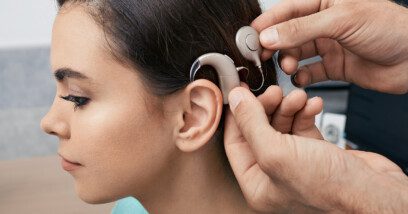Decorative image showing a young woman with a cochlear implant