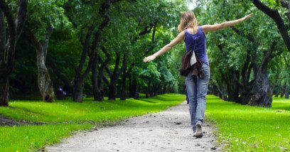 Woman walking on path in green summer park