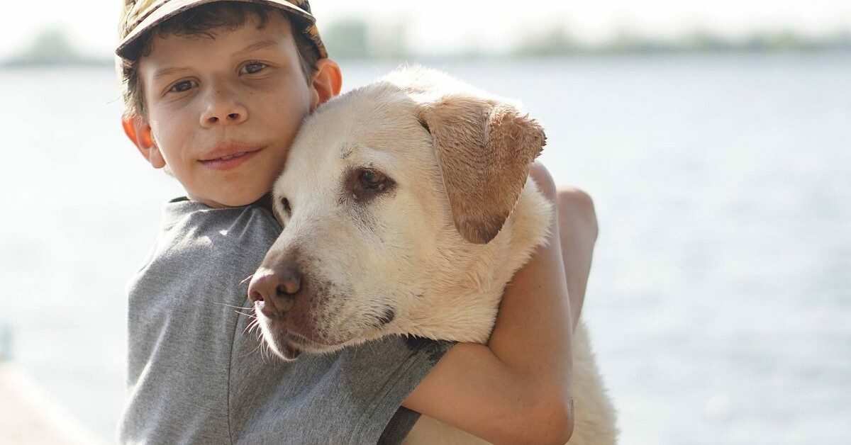 Young boy at the lake with his dog