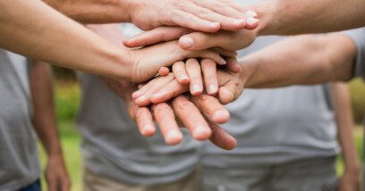Family standing in a circle and putting hands in the centre
