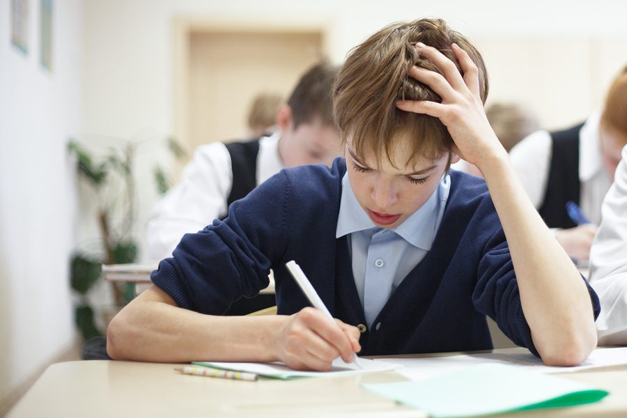 Boy struggling to finish school test
